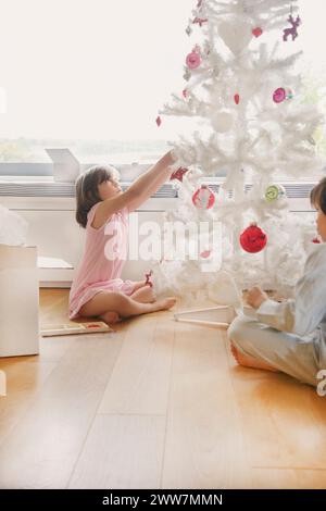 Junges Mädchen schmücken Weihnachtsbaum Stockfoto