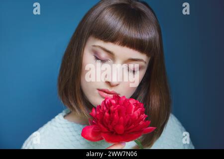 Nahaufnahme von Teenage Girl Holding Red Pfingstrose Stockfoto