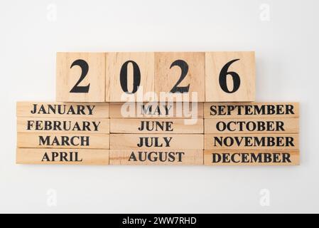Jahr 2026 auf Holzwürfeln geschrieben auf den Monaten des Jahres geschrieben auf zwölf rechteckigen Holzstücken. Isoliert auf weißem Hintergrund. Stockfoto