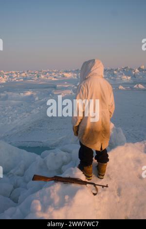 Ein Inupiaq-Existenzjäger steht auf rauem Packeis, nachdem er unweit der Küste, der Chukchi-See Alaska, instabile Meereisbedingungen beobachtet hat Stockfoto