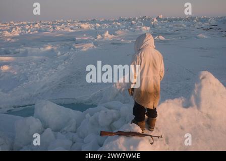 Ein Inupiaq-Existenzjäger steht auf rauem Packeis, nachdem er unweit der Küste, der Chukchi-See Alaska, instabile Meereisbedingungen beobachtet hat Stockfoto