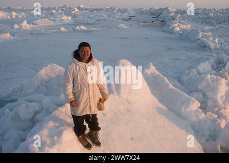 Ein Inupiaq-Existenzjäger steht auf rauem Packeis, nachdem er unweit der Küste, der Chukchi-See Alaska, instabile Meereisbedingungen beobachtet hat Stockfoto