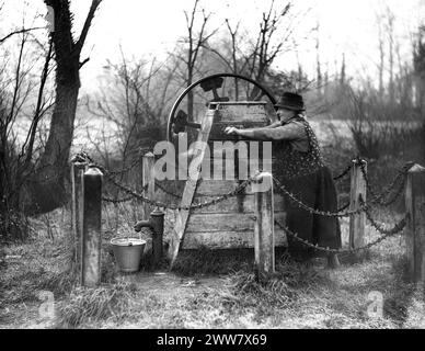 Frau pumpt Wasser aus einer öffentlichen Wasserpumpe in Kent, England, Großbritannien 1932 Stockfoto