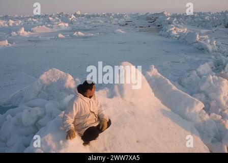 Ein Inupiaq-Existenzjäger steht auf rauem Packeis, nachdem er unweit der Küste, der Chukchi-See Alaska, instabile Meereisbedingungen beobachtet hat Stockfoto