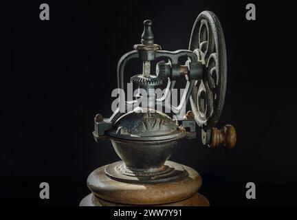 Detail des alten Original Kaffeemühle Metall-Rüttelrads mit Handkurbel auf dunklem Hintergrund. Nahaufnahme der Original-Kaffeebohne-Mahlmaschine, Copy Spa Stockfoto