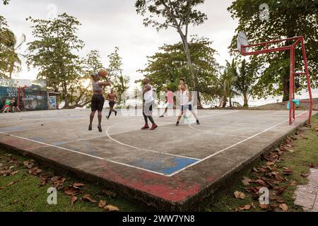 Einheimische spielen Basketball mit Touristen auf einem lokalen Basketballfeld in der Nähe des Strandes in Puerto Viejo an der Karibikküste, Costa rica Stockfoto