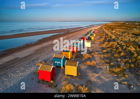 Findhorn Moray Coast Schottland Abend und eine Reihe von farbenfrohen Strandhütten mit Blick auf die weitläufige Küste und mit Marramgras bedeckte Sanddünen Stockfoto