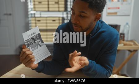 Ein afroamerikanischer Mann hält einen Flyer für eine vermisste Person im Haus, der Detektivarbeit in einer Polizeiabteilung porträtiert. Stockfoto