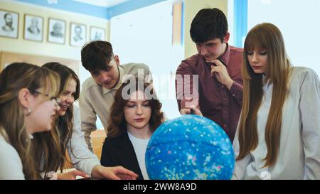 Die Schüler sehen in einem Klassenzimmer in der Schule einen Sternenhimmel. Stockfoto