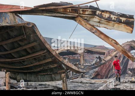 Manila, Philippinen. März 2024. Ein Mann sucht nach einem Brand in einem Slum-Gebiet in Manila, den Philippinen, am 22. März 2024 nach Habseligkeiten. Donnerstagnacht brach ein Feuer aus und zerstörte 140 Häuser, laut dem philippinischen Büro für Feuerschutz. Quelle: Rouelle Umali/Xinhua/Alamy Live News Stockfoto