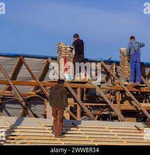 Dorfbewohner bauen gemeinsam ein Dach. Stockfoto