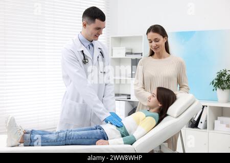 Gastroenterologe untersucht Mädchen mit Magenschmerzen auf der Couch in der Klinik Stockfoto