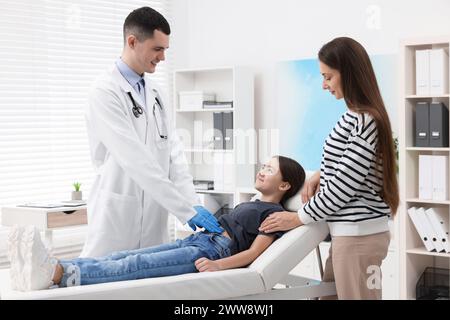 Gastroenterologe untersucht Mädchen mit Magenschmerzen auf der Couch in der Klinik Stockfoto