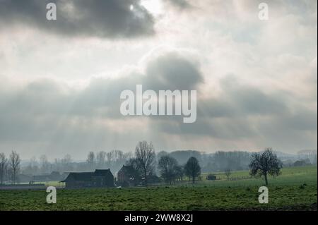 Eine dramatische Cloud scapel leuchtet auf einer ländlichen Landschaft im Belgischen Countriy Seite. Ostflandern An einem Winternachmittag im Frühjahr 2019. Stockfoto