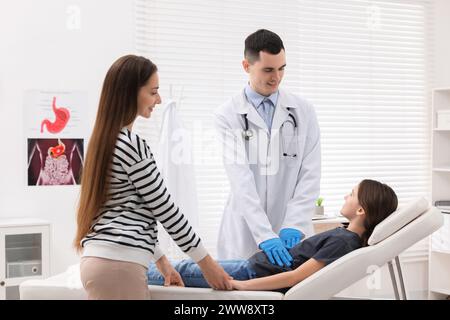 Gastroenterologe untersucht Mädchen mit Magenschmerzen auf der Couch in der Klinik Stockfoto