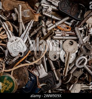 Nahaufnahme eines Tabletts mit alten Autoschlüsseln, Hausschlüsseln und antiken Schlüsseln. Glänzendes Metall, rostiges Metall. Konzept - Schlösser, Sicherheit, Türen, Recycling, alt, Stockfoto