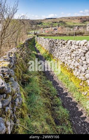 Schmaler, doppelwandiger Fußweg, der von Langcliffe zur Eisenbahnbrücke über die Eisenbahnstrecke Settle & Carlisle führt, Stockfoto