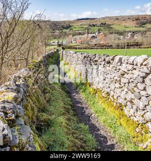 Schmaler, doppelwandiger Fußweg, der von Langcliffe zur Eisenbahnbrücke über die Eisenbahnstrecke Settle & Carlisle führt, Stockfoto