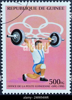 Von Guinea gedruckte Briefmarke, die Weight Lifting, Olympische Sommerspiele 1996 - Atlanta, um 1995 zeigt. Stockfoto