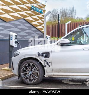 Nahaufnahme der Ladestation für Elektroautos, die von Käufern vor dem Primark-Geschäft im Merry Hill-Einkaufszentrum in den Midlands, Großbritannien, genutzt wird. Stockfoto