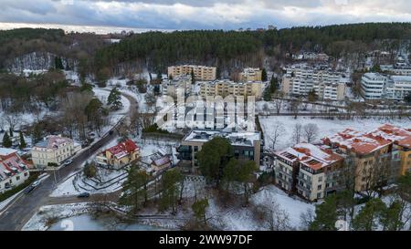 Drohnenfotografie von kleinen mehrstöckigen Häusern in der Nähe eines Waldes in einer Stadt während des bewölkten Winters Stockfoto