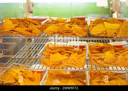 Knusprige Kartoffelchips mit verschiedenen Geschmacksrichtungen in Kunststoffbehältern. Cinephile Stockfoto