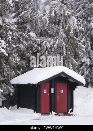 Zwei hölzerne Toiletten in der winterlichen Berglandschaft Stockfoto