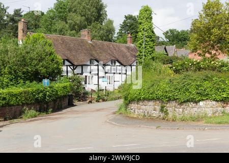 Hubbal Lane, Tong, Shropshire mit einem denkmalgeschützten Fachwerkhaus mit Augenbrauenrinnen. Das Haus war früher eine Reihe von Cottages. Stockfoto