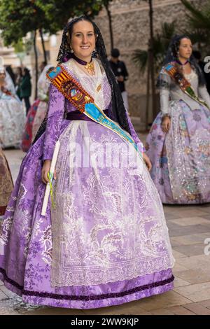 Valencianische Eleganz inmitten von Gandias festlicher Luft. Das Kostüm der Fallera, eine lebendige Feier der Tradition, verzaubert mit seinen reichen Wandteppichen und cultura Stockfoto
