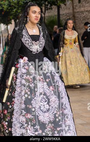 Valencianische Tradition in voller Darstellung: Die festliche Kleidung einer Fallera. Das Kleid, eine lebendige Leinwand der Geschichte, zieht mit Stolz und Elend durch die Straßen von Gandia Stockfoto