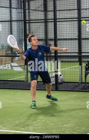 Padel-Tennisspieler mit Schläger in der Hand. Paddeltennis, auf grünem Hintergrund. Stockfoto