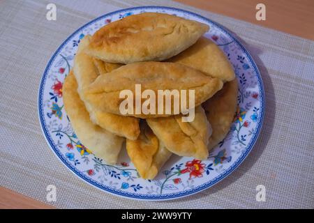 Gebratene Kuchen mit Kartoffeln und Zwiebeln auf einem Teller Nahaufnahme. Stockfoto