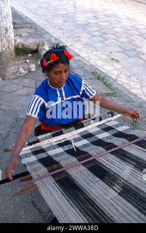 Tzotzil sprechende Maya-Indianerin aus San Juan Chamula webt traditionelle Brokatmotive auf ihrem traditionellen Backstrap-Webstuhl, Montag, 20. Dezember 1976 in San Juan Chamula, Chiapas Central Highlands, Südmexiko. Stockfoto