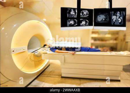 Ein Patient legt sich bequem auf den MRT-Scanner und unterzieht sich einer entspannenden MRT-Untersuchung, um den Oberbauch zu beurteilen und wichtige medizinische Erkenntnisse zu erhalten. Stockfoto