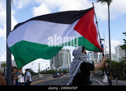 San Juan, USA. März 2024. Ein Mitglied von Boricuas por Palestina schwenkt die palästinensische Flagge während einer Demonstration, um gegen den Besuch von Vizepräsidentin Kamala Harris in Puerto Rico am Freitag, den 22. März 2024, zu protestieren. (Foto: Carlos Berríos Polanco/SIPA USA) Credit: SIPA USA/Alamy Live News Stockfoto