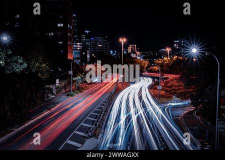 Lange Exposition des städtischen Verkehrs, wodurch ein Fluss des Lichts in der städtischen Nacht entsteht. Stockfoto