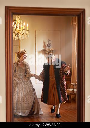 Renaissance, Mann und Frau halten Hände in königlicher Burg zusammen mit Vintage Liebe, Romantik und Bankett. Mittelalterliches King-Size-Bett, Queen-Size-Bett oder Paar im Ballsaal Stockfoto