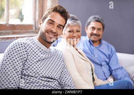 Erwachsener Sohn, Senioreneltern und Porträt mit Lächeln und Zuhause mit Glück und Wochenendbesuch. Wohnung, alte Mutter und reifer Vater mit Pause und Stockfoto