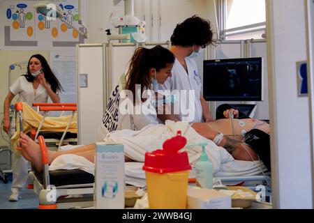 Schockraum auf der Intensivstation eines Universitätsklinikums. Der Arzt führt einen Ultraschall mit einem tragbaren Ultraschallgerät durch. Stockfoto