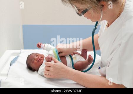 Der Kinderarzt überprüft die Herzfrequenz des Neugeborenen. Stockfoto