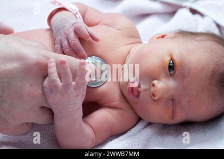 Der Kinderarzt überprüft die Herzfrequenz des Neugeborenen. Stockfoto