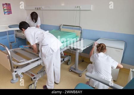 Kinderbetreuer, die ein Zimmer reinigen, nachdem ein Patient die Windelsuite verlassen hat. Stockfoto