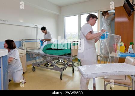 Kinderbetreuer, die ein Zimmer reinigen, nachdem ein Patient die Windelsuite verlassen hat. Stockfoto