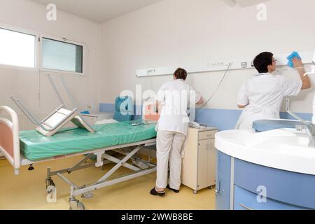 Kinderbetreuer, die ein Zimmer reinigen, nachdem ein Patient die Windelsuite verlassen hat. Stockfoto