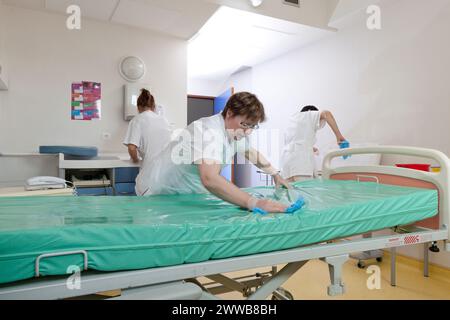 Kinderbetreuer, die ein Zimmer reinigen, nachdem ein Patient die Windelsuite verlassen hat. Stockfoto