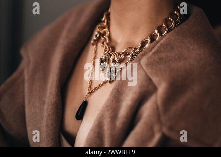 Eine goldene Kette hängt am Hals einer Frau. Wunderschöne elegante Luxusschmuck-Accessoires Stockfoto