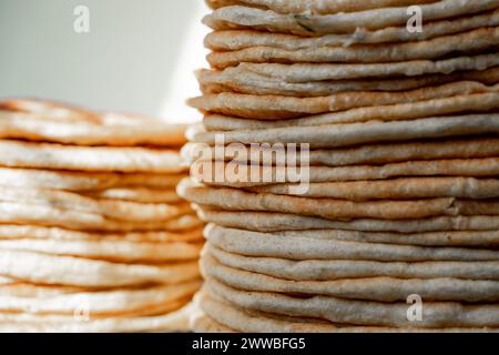 Fladenbrot Lavash, Chapati, Naan, ein Haufen Tortilla auf blauem Hintergrund hausgemachtes Fladenbrot gestapelt. Stockfoto