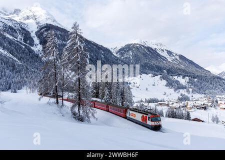 Berguen, Schweiz - 10. Januar 2024: Personenzug der Rhätischen Eisenbahn auf der Albula-Strecke in den Schweizer Alpen in Berguen, Schweiz. Stockfoto