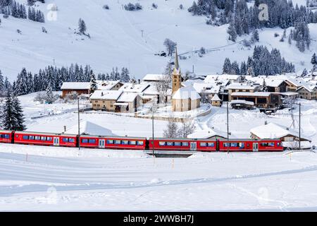 Berguen, Schweiz - 10. Januar 2024: Personenzug der Rhätischen Eisenbahn auf der Albula-Strecke in den Schweizer Alpen in Berguen, Schweiz. Stockfoto