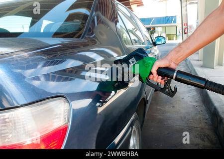 Die Hand des Mannes hält eine Gaspistole, betankt an einer Tankstelle. Ansicht schließen. Stockfoto